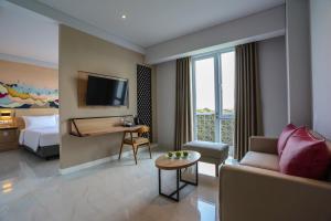 Pamanukan-hilirfavehotel Pamanukan的酒店客房设有一张沙发和一张床