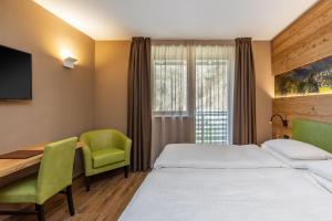 迪马罗Hotel Vittoria - Ricarica l'anima的配有一张床和一张书桌的酒店客房