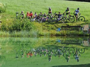 萨尔巴赫安德瑞拉马滑雪酒店的一群人在池塘旁骑着自行车
