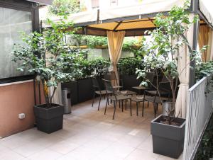 米兰索珀格酒店的庭院里种植了盆栽植物,配有桌椅