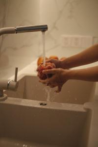 顺化Nhật Phương Hotel的一个人在水水龙头下面洗手