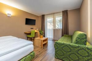 迪马罗Hotel Vittoria - Ricarica l'anima的酒店客房配有一张床、一把椅子和一张书桌