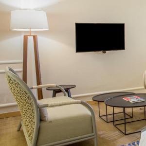 山口洋瑞士博里恩山口洋酒店的客厅配有椅子和电视