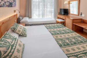 滨海托萨GHT绿洲托萨酒店&Spa的酒店客房设有两张床和电视。