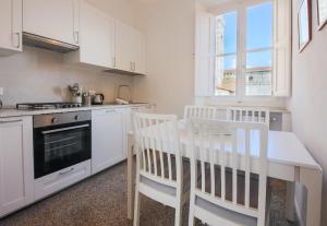 佛罗伦萨Apartments Florence - Florentine Skyline的厨房配有白色橱柜和桌椅