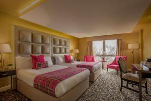 兰班克Gleddoch Golf & Spa Resort的两张位于酒店客房的床铺,拥有粉红色色调