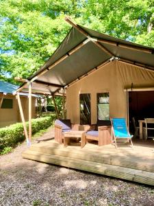 Vieilles-Maisons-sur-JoudryCAMPING ETANG DES BOIS的木制甲板上的帐篷,配有桌椅