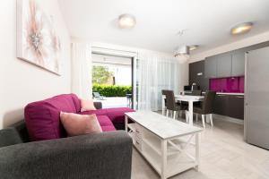 马林斯卡Waterfront Apartments Pia - Marija的客厅配有紫色沙发和桌子