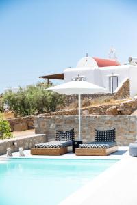 帕瑞加Dioni Villa Mykonos的一个带两把椅子和遮阳伞的游泳池