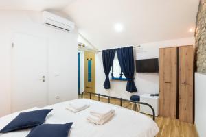 波尔托罗Istrian Casa Ladonia by Locap Group的一间卧室配有白色床和蓝色枕头
