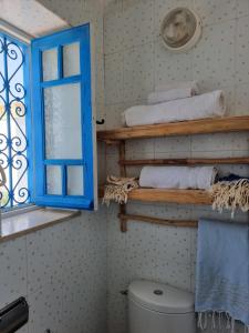 西迪·布·赛义德Cosy 1bdr, with a terasse in heart of Sidibou的浴室设有蓝色窗户和卫生间。