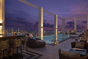 春武里Hotel Nikko Amata City Chonburi的屋顶酒吧,晚上可欣赏到城市美景