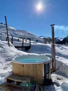 圣安特尼恩Berglodge Ascharina的滑雪场雪地中的热水浴池