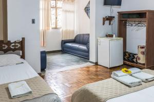 圣若昂-德雷普萨达多辛诺斯酒店的一间带两张床和一张沙发的客厅