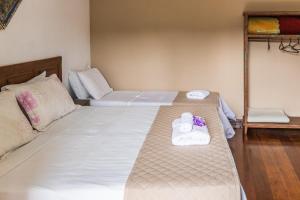 圣若昂-德雷普萨达多辛诺斯酒店的一间客房配有两张带毛巾和沙发的床。