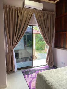 Kuala KerauTeratak Sekayu ( Room Stay )的卧室设有通往庭院的大玻璃门。