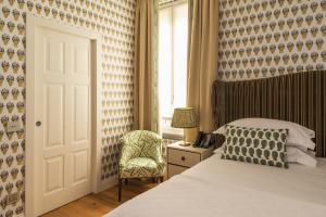 米兰Vmaison Brera Milano的卧室配有床、椅子和窗户。