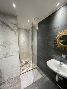 罗瓦涅米Wherever Mini Hostel的带淋浴、盥洗盆和镜子的浴室