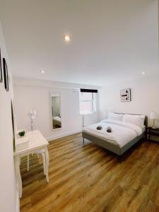 诺里奇Prosper House Apartment 4的白色卧室配有床和桌子