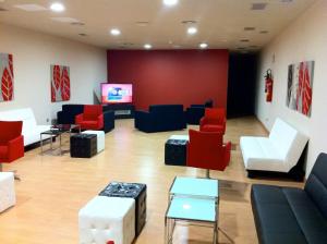 艾普约德加卡布巴尔公寓酒店的一间设有红色和蓝色椅子及屏幕的等候室