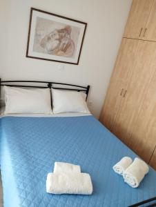 埃尔莫波利斯Syros House with View的一间卧室配有蓝色的床和2条毛巾