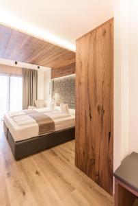 科戈洛科夫代尔利维因浪漫酒店的一间卧室设有一张大床和木墙