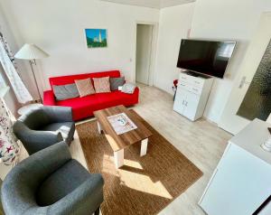 洛默Haus Ostseeblick的客厅配有红色沙发和茶几