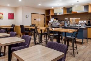埃尔帕索埃尔帕索机场舒适套房酒店的一间带桌椅和柜台的餐厅