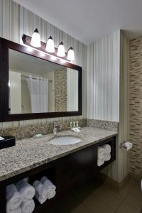 威廉斯堡威廉斯堡乡村酒店及套房的浴室配有盥洗盆、镜子和毛巾