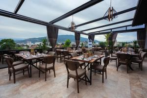 斯科普里Austrian Palace Hotel的餐厅设有桌椅和大窗户。