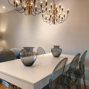 巴塞罗那Mediterranean Barcelona Apartments的一间用餐室,配有一张白色桌子和花瓶