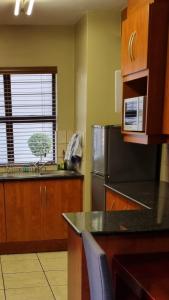 比勒陀利亚Homely Apartment, Hatfield, Unit-9的厨房配有水槽和冰箱