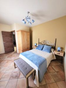 哈拉瓦CASA RURAL SANTA AGUEDA的一间卧室配有一张大床和一个吊灯。