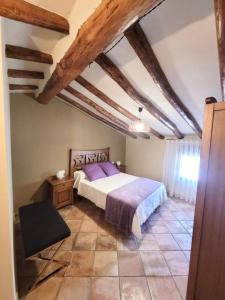 哈拉瓦CASA RURAL SANTA AGUEDA的一间卧室配有一张带紫色床单的大床
