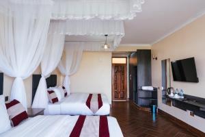 内罗毕Olsupat Lodge的酒店客房设有两张床和一台平面电视。