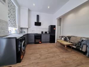 普雷斯顿Cheerful 4 bedroom close to Uclan, Preston City Center的一间带炉灶的厨房和一张沙发