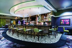 圣安东尼奥La Quinta Inn & Suites by Wyndham San Antonio Riverwalk的一间酒吧,位于酒店客房内,配有椅子和柜台