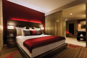 圣地亚哥圣地亚哥硬石酒店的一间卧室配有一张大床和红色床头板