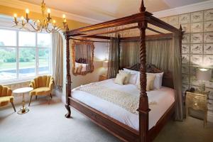 索尔兹伯里格拉斯米尔别墅酒店的一间卧室配有一张天蓬床和吊灯。