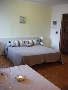 庞迪底雅科Monolocale Serafini Appartamenti Comano Terme的一张位于带酒杯桌子的房间的床位