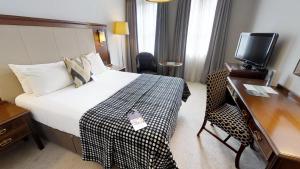 埃克塞特埃克塞特南门美居酒店的酒店客房配有一张床、一张书桌和一台电视。