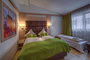 福森福森贝斯特韦斯特酒店的一间卧室配有一张带绿毯的大床