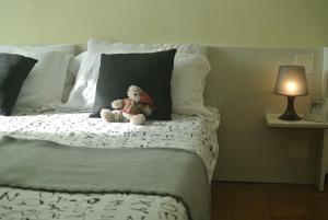 庞迪底雅科Monolocale Serafini Appartamenti Comano Terme的睡在床上的泰迪熊