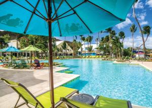 弗雷德达尔Margaritaville Vacation Club by Wyndham - St Thomas的一个带椅子和遮阳伞的度假村游泳池
