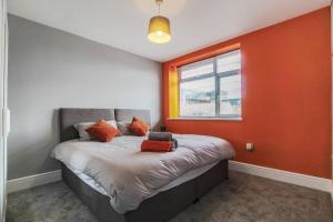布里斯托PRIME LOCATION - Modern Central Apartment的一间卧室配有一张橙色墙壁的床
