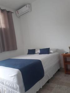 乌巴雅拉Pousada Central-Ubajara Capital do Turismo的一间卧室配有一张带蓝白色床单的大床