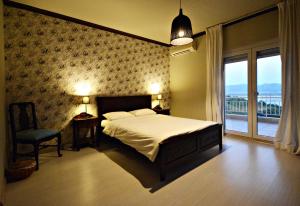 卡斯托里亚Guesthouse Vissinokipos - Biker Friendly - Motorradhotel的一间卧室设有一张床和一个大窗户