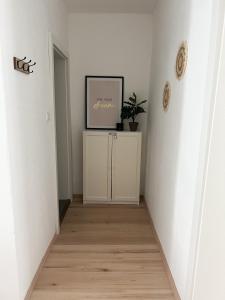 格蒙登Apartment in Gmunden的走廊上设有白色的墙壁和墙上的照片