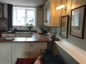 卡马森Wren Cottage的厨房配有白色橱柜和台面