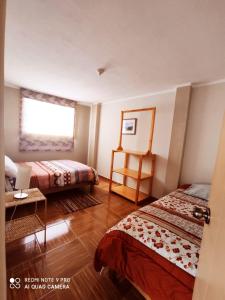 瓦拉斯Departamentos Bellavista La Alborada Huaraz的酒店客房设有两张床和窗户。